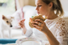 woman-experiencing-compulsive-eating-before-period-holding-a-sandwich.jpg